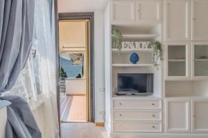 a room with a tv and a dresser with a television at Blu al Lago in Lierna