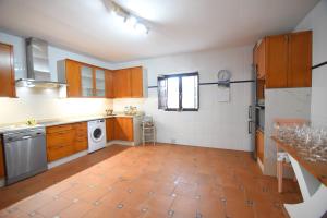 a kitchen with wooden cabinets and a tile floor at La casona de Llano in Los Corrales de Buelna