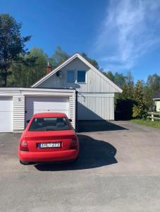 un coche rojo estacionado frente a un garaje en Own private room in a big house! en Luleå
