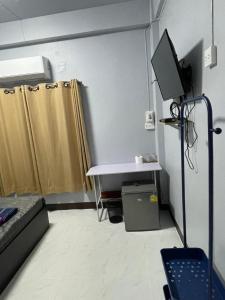 um quarto com uma cama, um lavatório e uma televisão em เส้นดี โฮสเทล Sendee Hostel em Phitsanulok