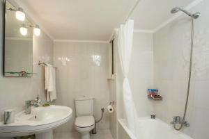 a white bathroom with a toilet and a sink at Pelagias apartments in Rhodes Town +11 photos