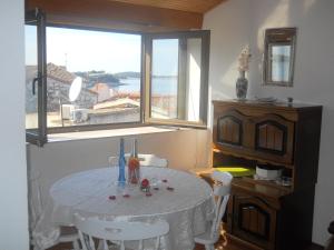 a table and chairs in a room with a window at Apartments Ada Novak in Hvar