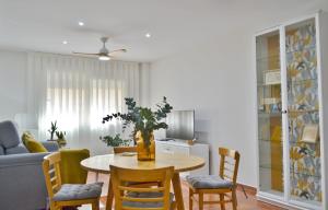 un soggiorno con tavolo, sedie e divano di SunShine Tejares Garden a Cordoba