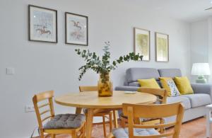 un soggiorno con tavolo, sedie e divano di SunShine Tejares Garden a Cordoba