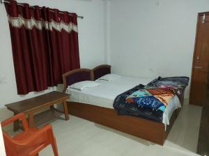 1 dormitorio con cama y cortina roja en Rama Guest House, en Bodh Gaya