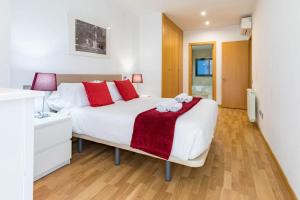 1 dormitorio con 1 cama blanca grande con almohadas rojas en Cituspace Las Tablas Camino Santiago, en Madrid
