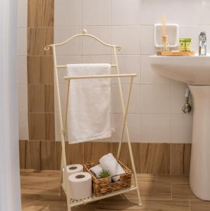 Baño con toallero con papel higiénico y lavamanos en 4keys House 2, en Tripolis