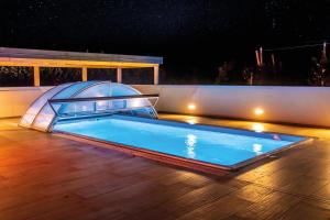 a swimming pool with a cover on a deck at night at Wiesenheim in Castelbello-ciardes +2 photos