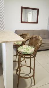 twee rieten stoelen naast een tafel bij Loft encantador próximo a Roda Gigante,excelente localização com ar condicionado in Balneário Camboriú