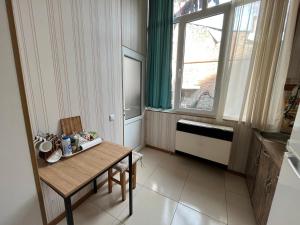 um pequeno quarto com uma mesa e uma janela em Sunny Apartments em Tbilisi