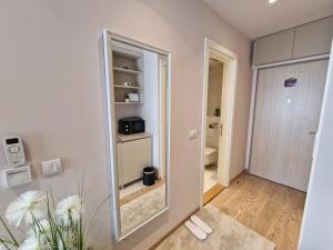 a room with a mirror and a bathroom at Beograd na vodi - BW AURORA LUXURY in Belgrade