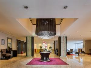 a lobby with a large chandelier and a table at Exe Alameda Reforma in Mexico City