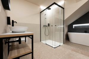 a bathroom with a glass shower and a sink at URBAIA ROOMS in San Sebastián