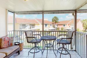 a balcony with a table and chairs and a couch at Bermuda Bay Beach & Racquet Club, Unit E in St Petersburg
