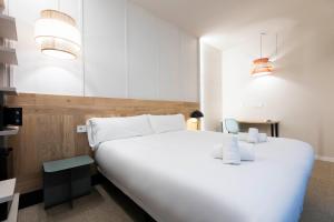 圣塞瓦斯蒂安URBAIA ROOMS的卧室里有一张白色的大床和一张书桌
