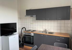 een keuken met zwarte kasten, een wastafel en een fornuis bij Apartment with 3 rooms in Hürth in Hürth