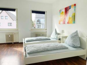 twee bedden in een kamer met twee ramen bij Apartment with 3 rooms in Hürth in Hürth
