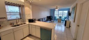 a kitchen with a sink and a living room at Gulfview I #213 in South Padre Island