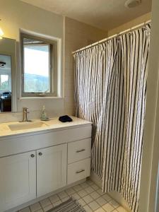 a bathroom with a sink and a shower curtain at The Harmony Studio at Wind Walker Homestead in Spring City
