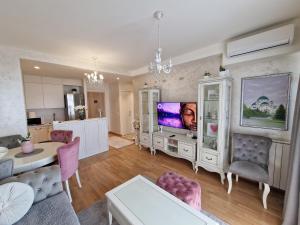 a living room with a tv and a kitchen at Beograd na vodi - BW ViSTA LUXURY in Belgrade