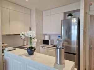 a kitchen with a refrigerator and a vase of flowers on a counter at Beograd na vodi - BW ViSTA LUXURY in Belgrade