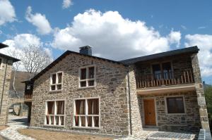 a stone house with a balcony on top of it at Alojamiento Rural El atardecer de Sanabria in San Juan de la Cuesta