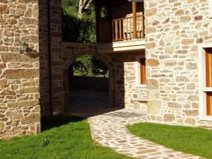 Zugang zu einem Steingebäude mit einem Balkon in der Unterkunft Alojamiento Rural El atardecer de Sanabria in San Juan de la Cuesta