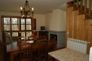 eine Küche und ein Esszimmer mit einem Tisch und einem Kamin in der Unterkunft Alojamiento Rural El atardecer de Sanabria in San Juan de la Cuesta