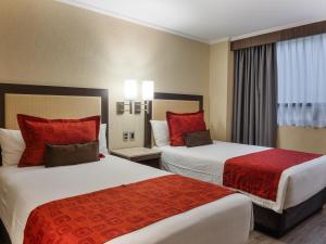a hotel room with two beds with red pillows at Exe Alameda Reforma in Mexico City +32 photos
