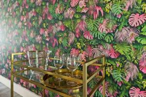 a table with wine glasses in front of a floral wall at Treasure Island - Modern Miami House 3 Bedroom & 2 Bathroom in Miami Beach