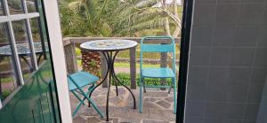 uma mesa e duas cadeiras sentadas numa varanda em Casa do Gato Preto em Santo Amaro