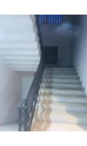 a staircase in a building with a wooden floor at Redbell Inn Airport Hotel in Kondotti