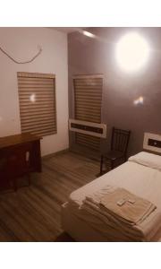 ein Hotelzimmer mit einem Bett, einem Schreibtisch und einem Schreibtisch in der Unterkunft Redbell Inn Airport Hotel in Kondotti