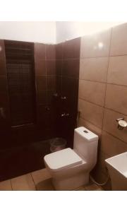 a bathroom with a toilet and a sink at Redbell Inn Airport Hotel in Kondotti