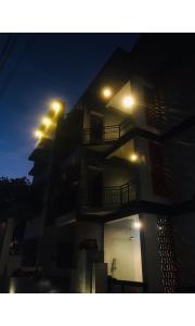 een nachtzicht op een gebouw met verlichting aan bij Redbell Inn Airport Hotel in Kondotti