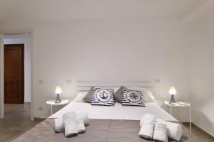 um quarto branco com uma grande cama branca com almofadas em Cosy and Modern Apartment Portu Frailis em Àrbatax