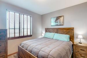 a bedroom with a bed and a dresser and windows at Sunset Beach House in Coos Bay