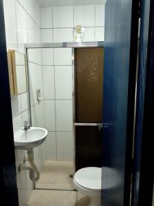 małą łazienkę z toaletą i umywalką w obiekcie Hostel Pé na praia - Quartos e Barracas Camping w mieście Caraguatatuba