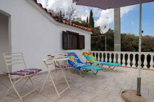 a patio with chairs and a table and an umbrella at Georgias Loft Acharavi Corfu in Acharavi
