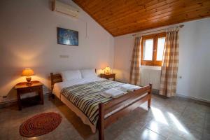 een slaapkamer met een bed met 2 lampen en een raam bij Georgias Loft Acharavi Corfu in Acharavi