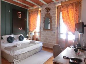 1 dormitorio con 2 camas, mesa y TV en Les Monges Palace Boutique en Alicante