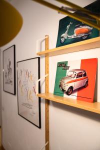 une étagère avec une voiture jouets et des photos sur celle-ci dans l'établissement Bubi House Porta Venezia, à Milan