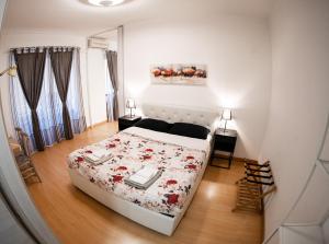 - une chambre avec un lit blanc et un couvre-lit floral dans l'établissement Bubi House Porta Venezia, à Milan
