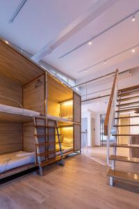 a room with bunk beds and a staircase at Boxpackers Pratunam in Bangkok