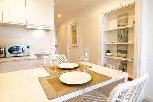 una cocina con una mesa con dos platos y copas de vino en Sea Lovers - Sea front - studio apartment, en Monte Gordo
