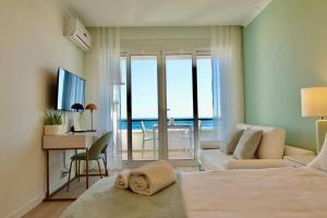 Cet appartement comprend une chambre avec un lit et un salon avec un bureau. dans l'établissement Sea Lovers - Sea front - studio apartment, à Monte Gordo