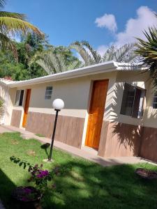una casa con una puerta de madera en un patio en Recanto da Praia Kitnetes en Caraguatatuba