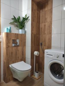 a bathroom with a toilet and a washing machine at Apartament Jagiełły 14 in Giżycko
