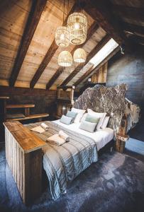 a bedroom with a bed and chandeliers at Les Mazots des Fées in Morzine