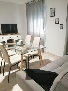 - un salon avec une table en verre et des chaises blanches dans l'établissement CALDERON, à La Roda